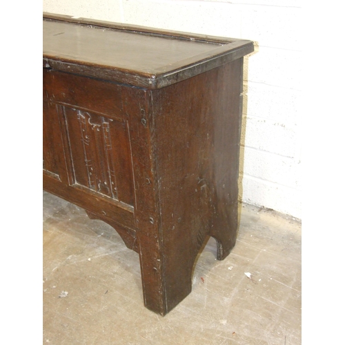 52 - An antique oak six-plank coffer, unusually the lid applied with moulded edge, the front panel carved... 