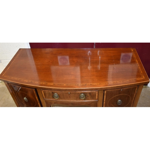 22 - A Georgian-style inlaid mahogany bow-fronted sideboard fitted with two cupboard doors and a drawer, ... 