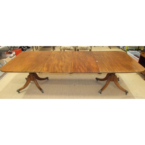 38 - A Georgian mahogany twin-pillar dining table, the top including two spare leaves supported on turned... 