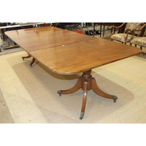 38 - A Georgian mahogany twin-pillar dining table, the top including two spare leaves supported on turned... 