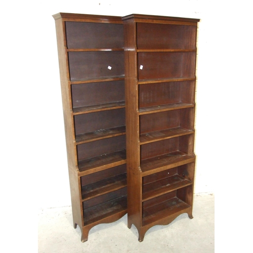 52 - Two similar mahogany waterfall bookcases, each with narrow cornice above seven shelves, on splayed b... 