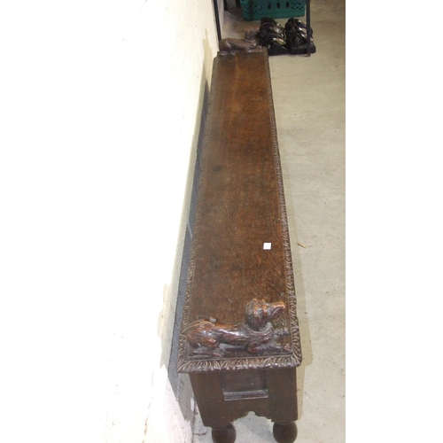 53 - An unusual antique oak low hall settle of panelled construction, the rectangular later hinged top ha... 