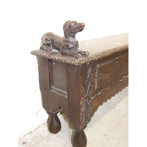 53 - An unusual antique oak low hall settle of panelled construction, the rectangular later hinged top ha... 