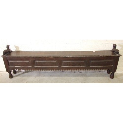 53 - An unusual antique oak low hall settle of panelled construction, the rectangular later hinged top ha... 