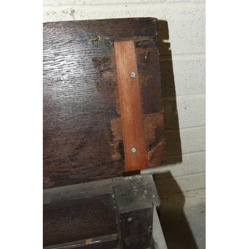 53 - An unusual antique oak low hall settle of panelled construction, the rectangular later hinged top ha... 