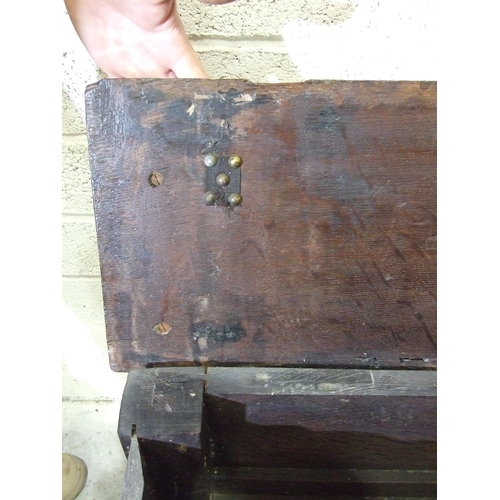 53 - An unusual antique oak low hall settle of panelled construction, the rectangular later hinged top ha... 