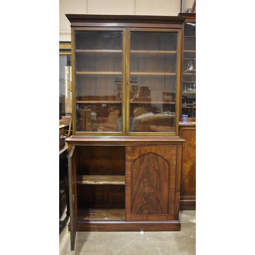 7 - An early-19th century mahogany two-door cupboard with bookcase above, 114cm wide, 207cm high.... 