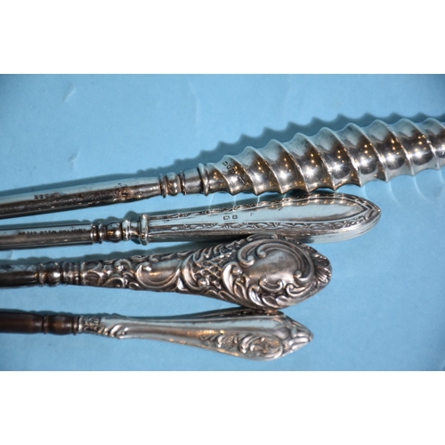 22 - A steel button hook with spiral silver handle, 23cm long, Birmingham 1901, three other silver and on... 