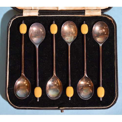24 - A cased set of six silver 'bean' coffee spoons, Sheffield 1936, two silver napkin rings, a white met... 