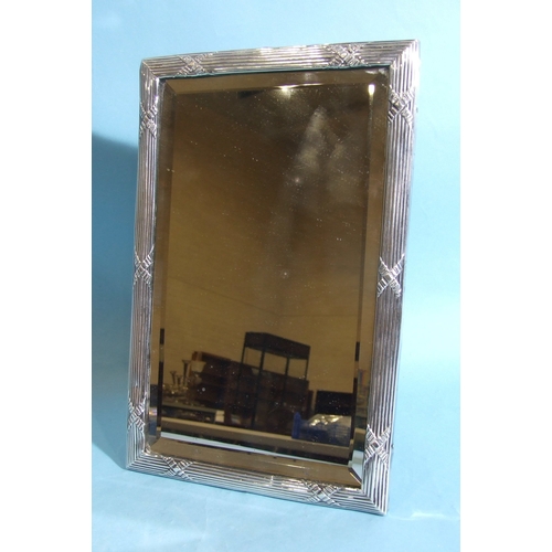 39 - An Edwardian silver-framed rectangular table mirror with relief-embossed reed and ribbon decoration ... 