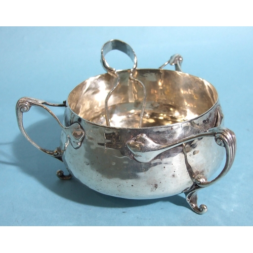 45 - An Edwardian silver circular sugar bowl in the Art Nouveau style, having three tendril-shaped handle... 