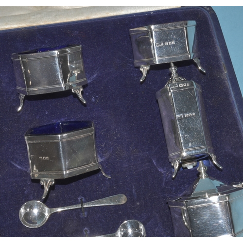 6 - A cased silver double cruet set of plain hexagonal form, London 1924, with blue glass liners, 253g, ... 
