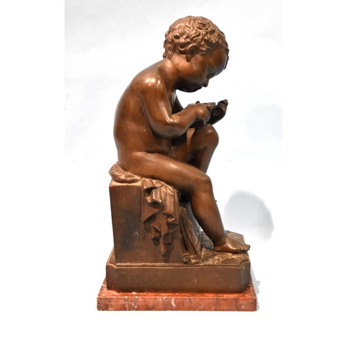 23 - A 19th century bronze Le Petit Ecrivain, depicting a child writing on a tablet and seated on a plint... 