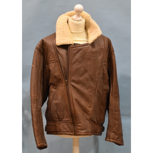 55 - A brown leather and sheepskin flying jacket, no manufacturer's label, size 12, (worn) and another wi... 