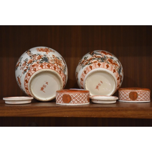 42 - A pair of Japanese Arita ginger jars with interior covers and lids decorated with blossom and birds,... 