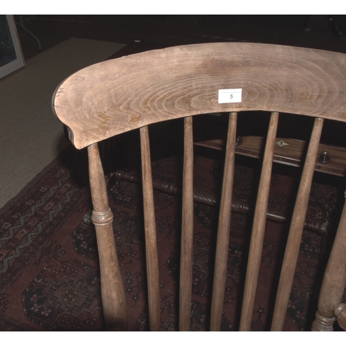 5 - An elm and beech farmhouse armchair, with spindle back, solid seat and splayed turned legs, 111cm hi... 