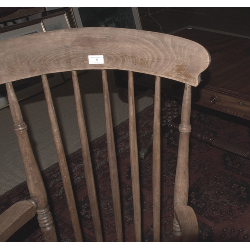 5 - An elm and beech farmhouse armchair, with spindle back, solid seat and splayed turned legs, 111cm hi... 