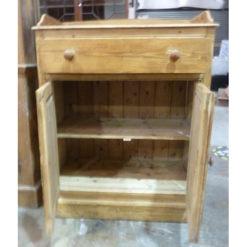 1 - A pine cupboard, the rectangular galleried top above a single frieze drawer and a pair of cupboard d... 