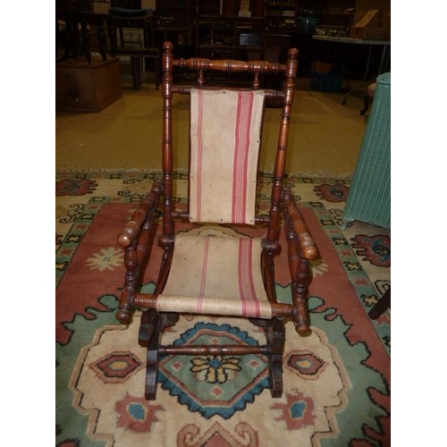 17 - A late-19th century child's American-style stained turned wood rocking chair, a cane-seated chair an... 