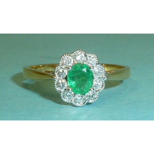 303 - An emerald and diamond cluster ring, claw-set an oval emerald within a border of ten brilliant-cut d... 