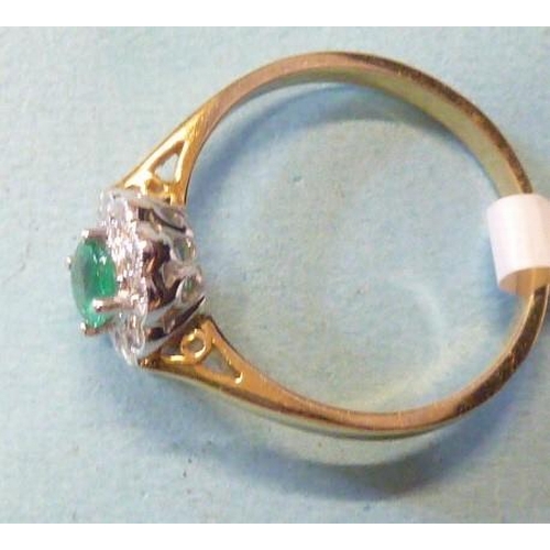 303 - An emerald and diamond cluster ring, claw-set an oval emerald within a border of ten brilliant-cut d... 