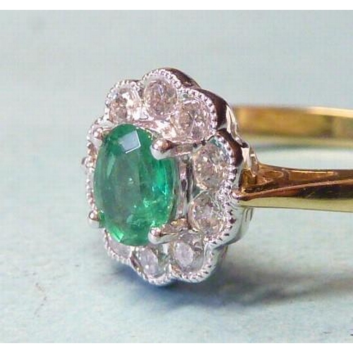 303 - An emerald and diamond cluster ring, claw-set an oval emerald within a border of ten brilliant-cut d... 