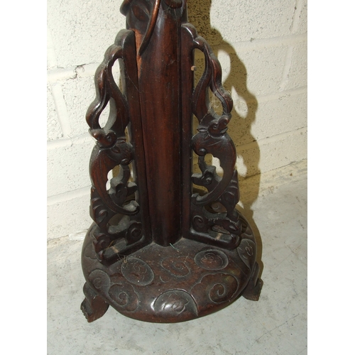 51 - An Oriental carved hardwood lamp stand, 175cm high and an Oriental watercolour of a female figure ho... 