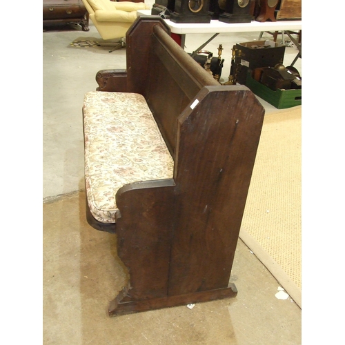 34 - An antique small oak pew of panelled construction, with leaf-carved arms, 116cm wide, 90cm high.... 