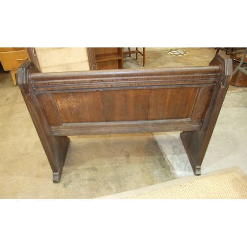 34 - An antique small oak pew of panelled construction, with leaf-carved arms, 116cm wide, 90cm high.... 