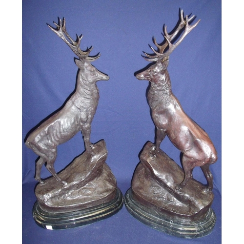 40 - Large pair of bronzed stags mounted on rocky outcrop and stepped oval marble bases (75cm high)