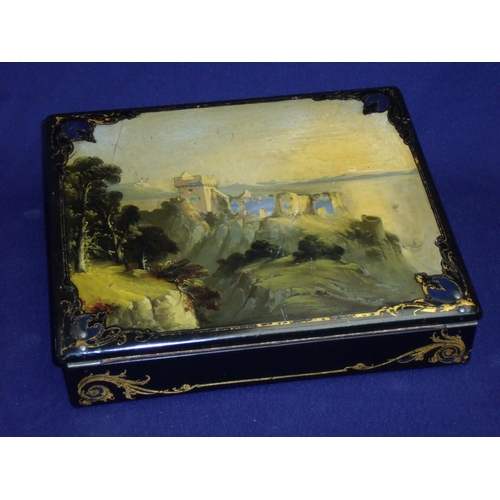 54 - Late Victorian lacquered and gilt work writing box, the fold over top with painted detail of a castl... 