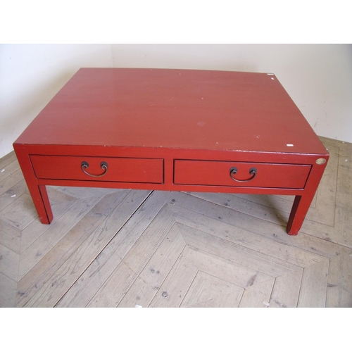 381 - Large Japanese style red lacquered rectangular two drawer coffee table on square supports (90cm x 12... 