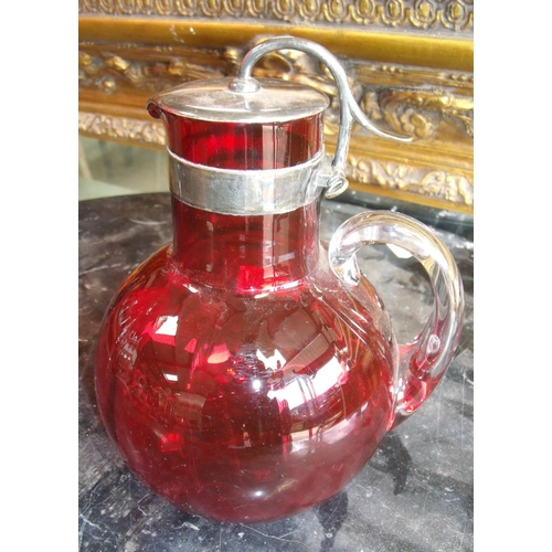 161 - Cranberry glass jug with clear glass loop handle and silver plated cover and mounts stamped Patent 1... 