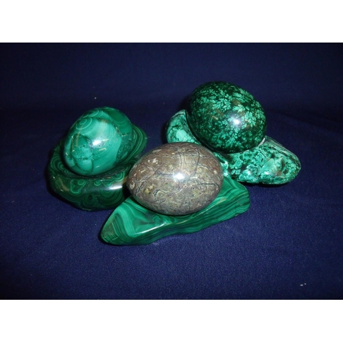 8 - Three carved hard stone eggs including green malachite, with associated carved stone stands/mounts (... 