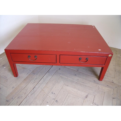 212 - Large Japanese style red lacquered rectangular two drawer coffee table on square supports (90cm x 12... 