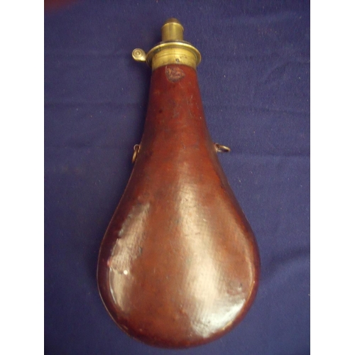 121 - Large bodied brown leather cupboard powder flask of typical swollen bag shape with brass dispensing ... 