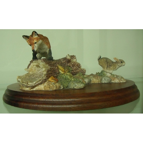 107 - Border Fine Arts figure of a fox and hare (hare lacking an ear), mounted on oval wooden plinth