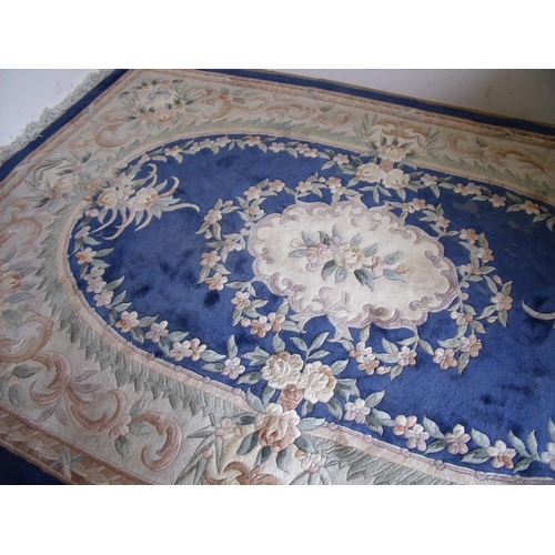 295 - Large blue & beige ground Chinese woollen rug with central floral panel (185cm x 300cm)