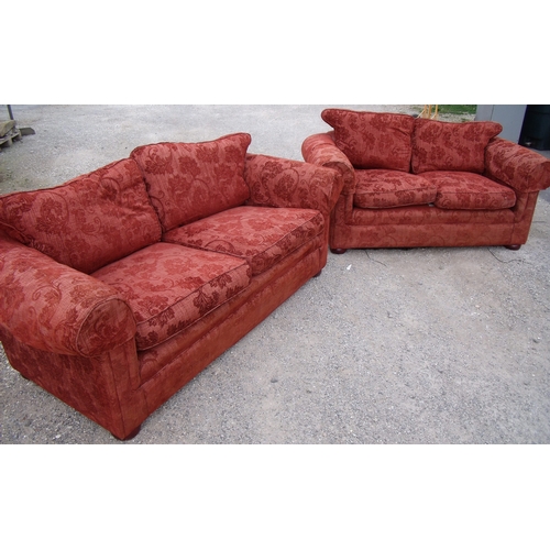 292 - Modern two piece suite in red upholstery comprising of a large two seat sofa and smaller two seat so... 