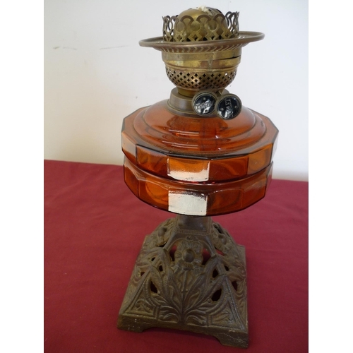 58 - 19th/20th C oil lamp with amber glass reservoir and cast metal base