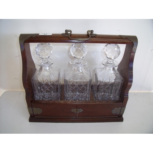 13 - Modern mahogany three sectional Tantalus with three glass decanters