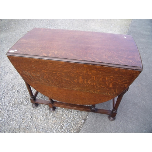 428 - Oak drop leaf gate leg table on carved supports