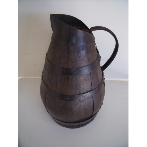 50 - Large iron coopered oak jug of tapering form with loop handle (48cm high)