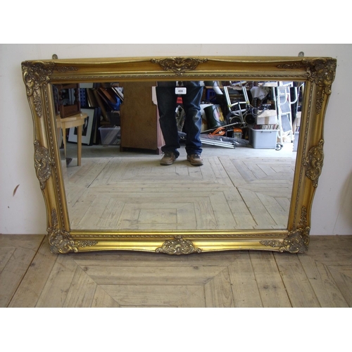 400 - Bevelled edge mirror in ornate gilt frame (width 106cm)