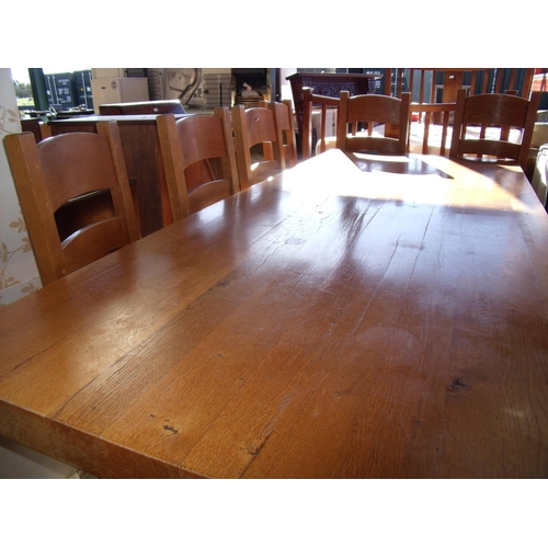 437 - A large heavy oak dining table with X shaped under tier and stretcher (length 240cm) and a set of si... 