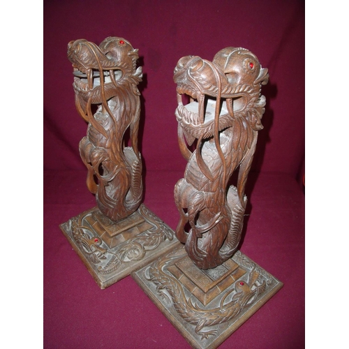 119 - Pair of carved hardwood figures of Chinese dragons mounted on square bases with carved detail of a f... 