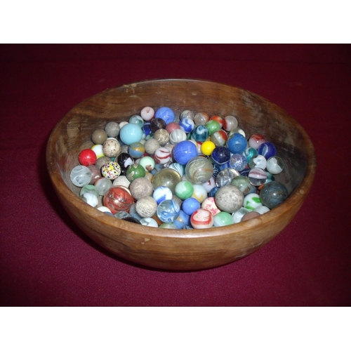 70 - Turned wood bowl containing a large selection of 19th C and later marbles (bowl diameter 21cm)