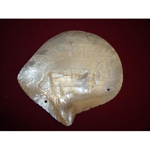 81 - Large carved Mother of Pearl shell depicting various figures within buildings and landscape setting ... 