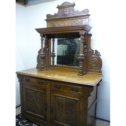 390 - Late 19th/early 20th C elaborately carved oak mirror backed sideboard with carved mask pediment flan... 