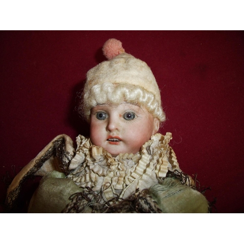 9 - Scarce and unusual French porcelain hand spinning doll, the porcelain head with blue glass eyes and ... 